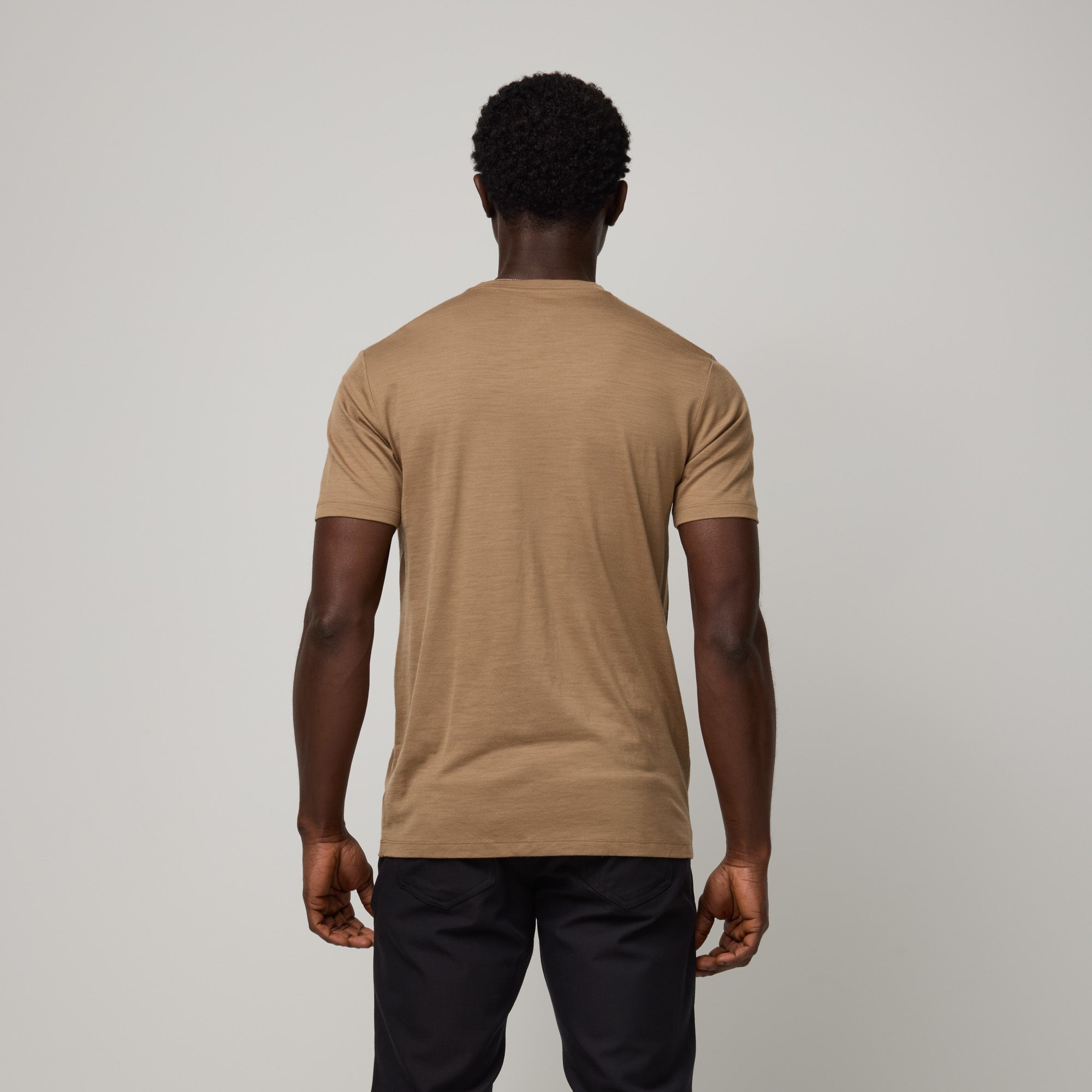 Model wearing 100% Merino Wool T-Shirt in Cedarwood, a warm soft brown color. This short sleeve, crew neck t-shirt is available in sizes XS-XXL.