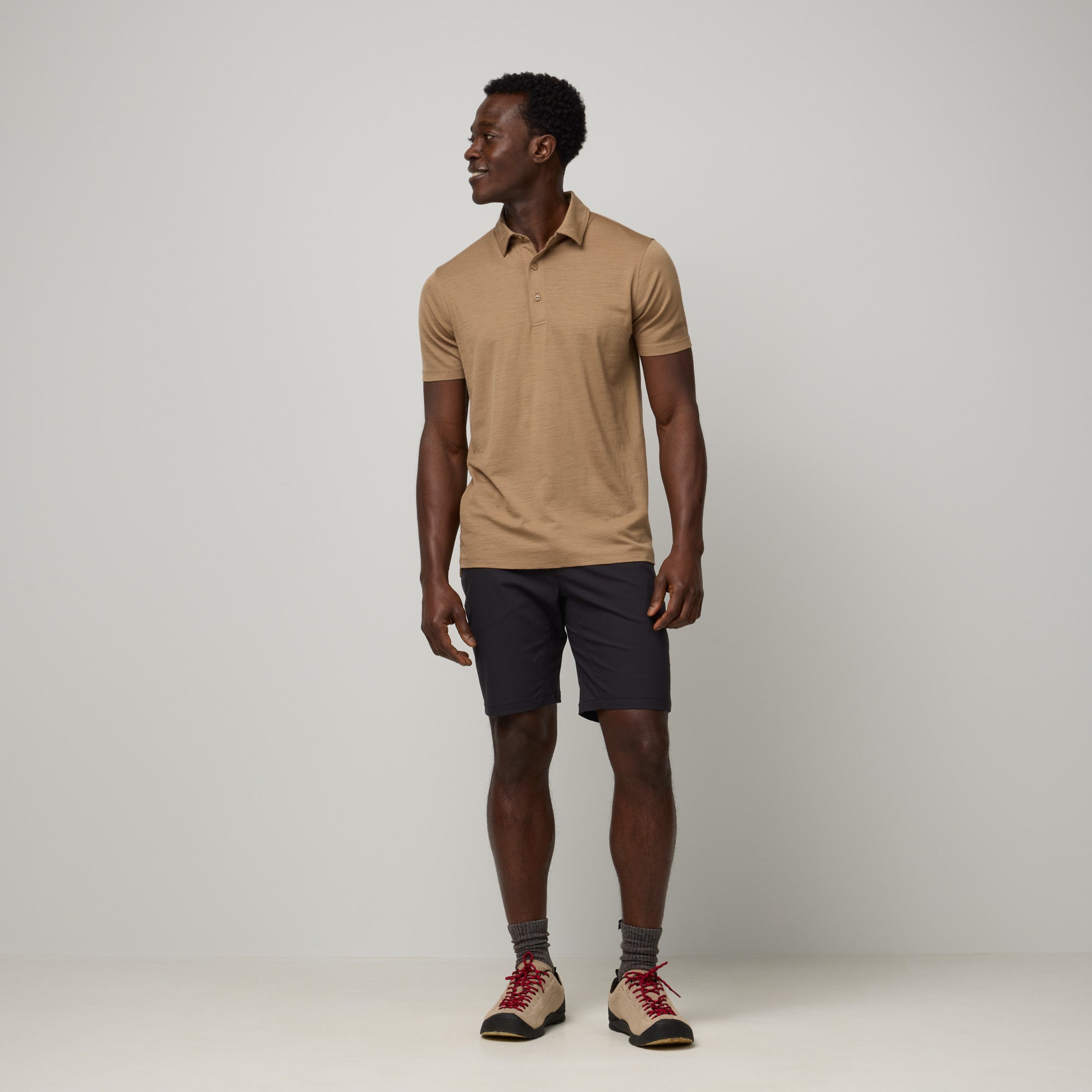 Model wearing 100% Merino Wool Polo Shirt in Cedarwood, a warm soft brown color. This short sleeve, crew neck t-shirt is available in sizes XS-XXL.