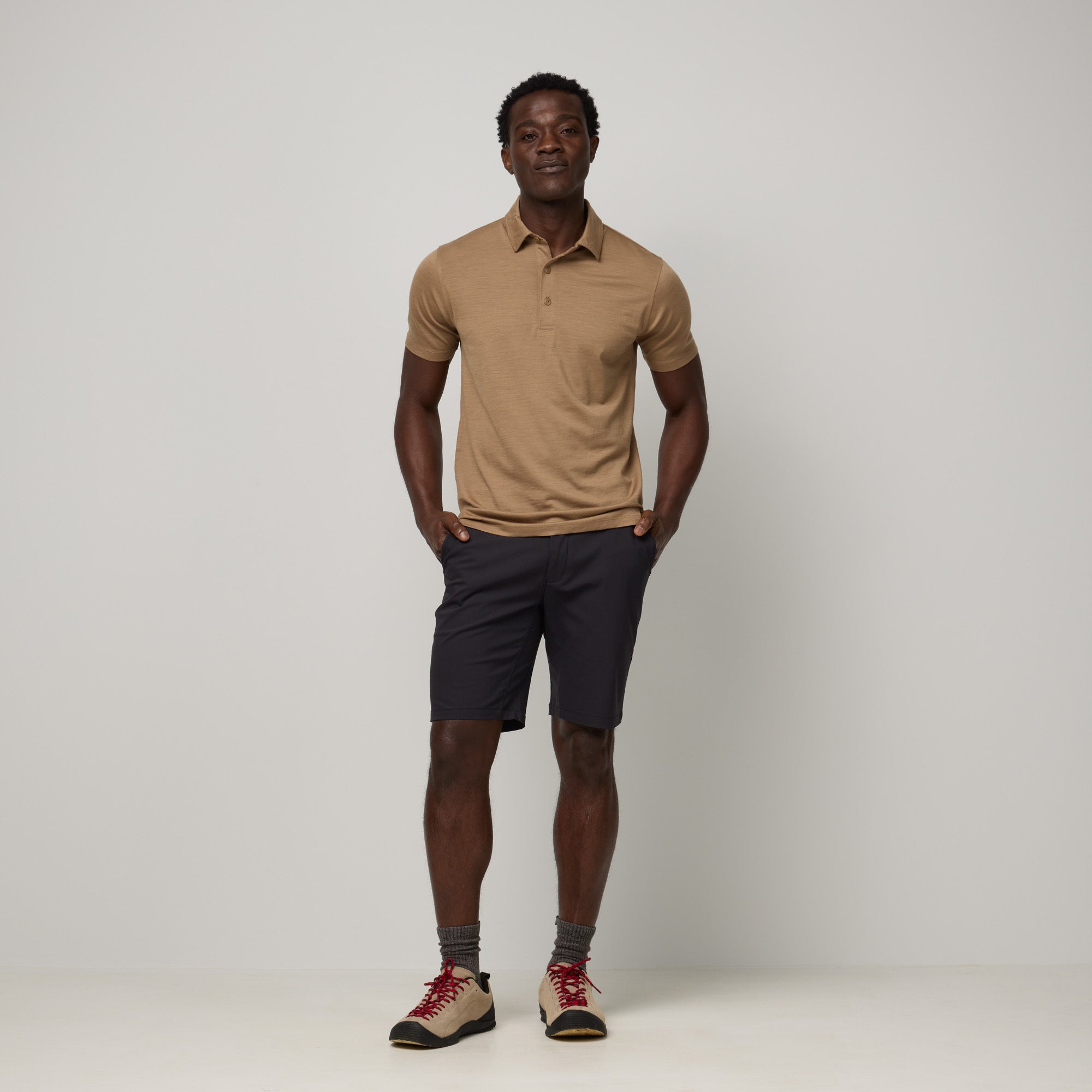 Model wearing 100% Merino Wool Polo Shirt in Cedarwood, a warm soft brown color. This short sleeve, crew neck t-shirt is available in sizes XS-XXL.
