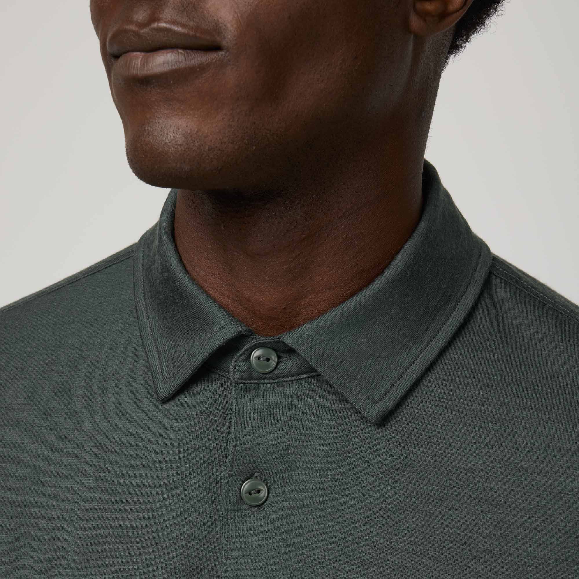 Model wearing 100% Merino Wool Polo Shirt in Hunter Green, a dark green with blue undertones. This short sleeve, crew neck t-shirt is available in sizes XS-XXL.