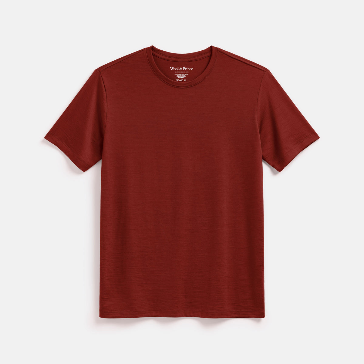 Laydown of merino wool Signature Crew Neck Tee in Rustic Red, a brick red color. This is a short sleeve, crew neck tee available in sizes XS-2X