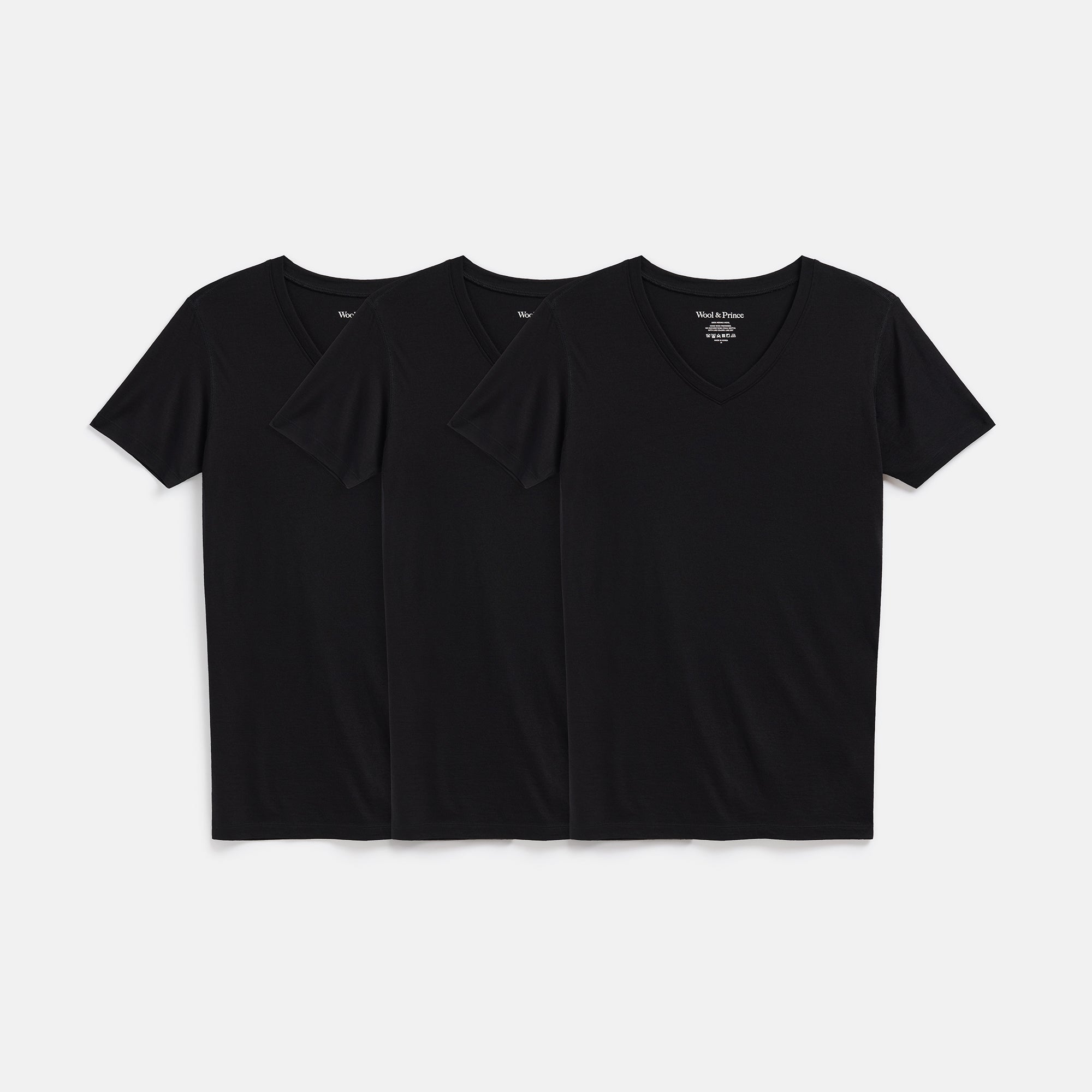 Laydown of a bundle of 3 100% merino wool undershirts in Black.