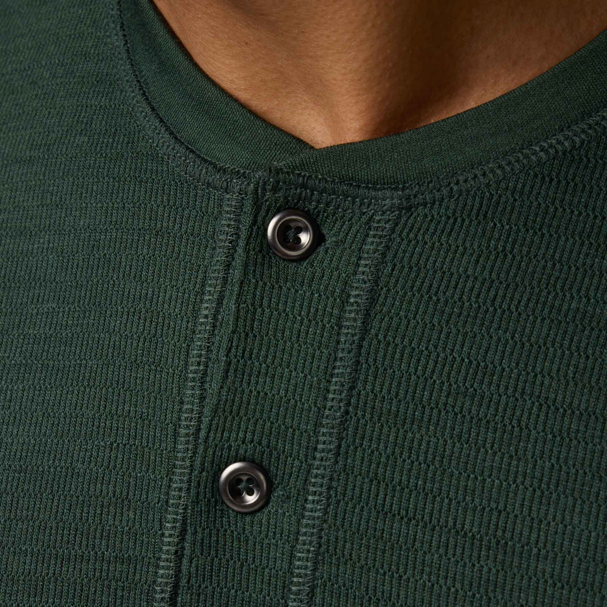 Detail of merino wool Waffle Henley in Hunter Green, a dark green with blue undertones. This is a long sleeve, crew neck henley shirt available in sizes XS-XXL.
