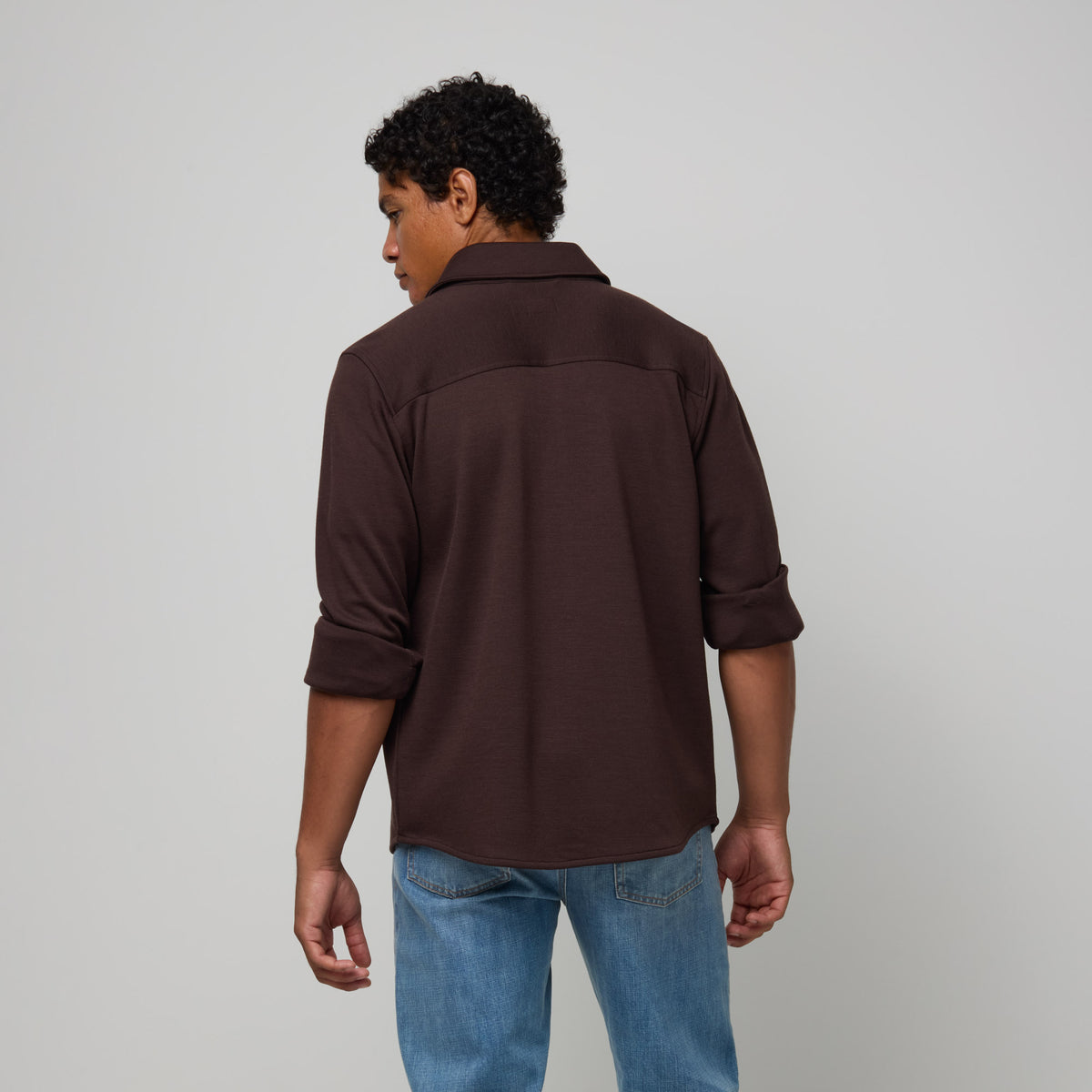 Model wearing merino wool Midweight Pique Button-Down Shirt in Espresso, a dark brown color. This is a long sleeve, collared, casual button-down shirt available in sizes S-XXL.
