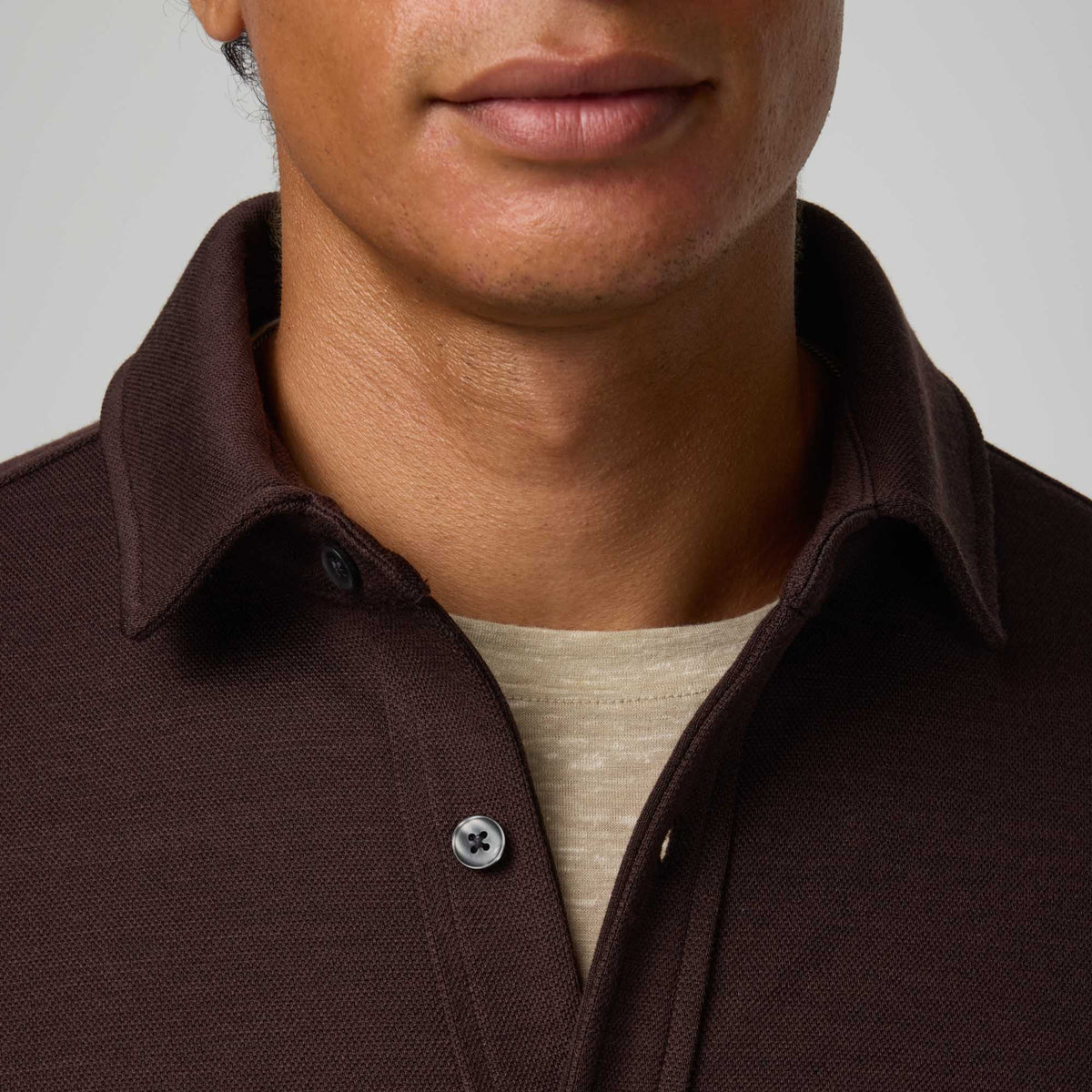 Model wearing merino wool Midweight Pique Button-Down Shirt in Espresso, a dark brown color. This is a long sleeve, collared, casual button-down shirt available in sizes S-XXL.