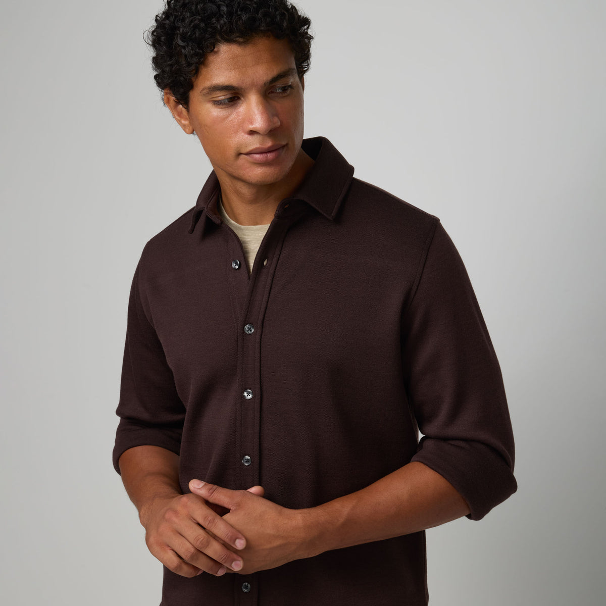 Model wearing merino wool Midweight Pique Button-Down Shirt in Espresso, a dark brown color. This is a long sleeve, collared, casual button-down shirt available in sizes S-XXL.