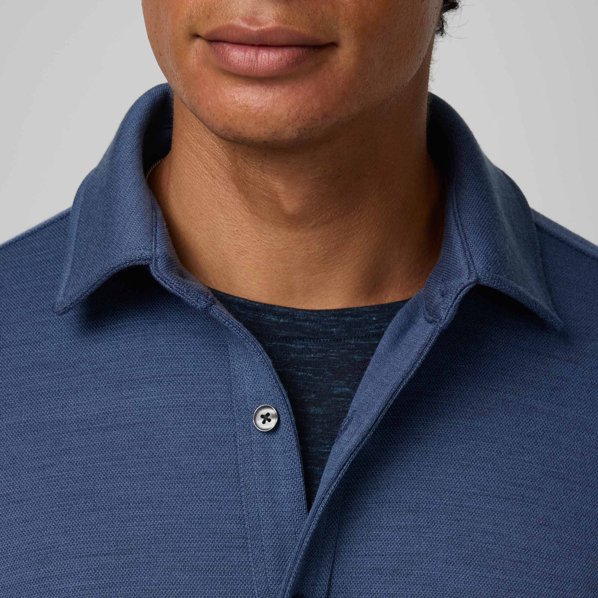 Model wearing merino wool Midweight Pique Button-Down Shirt in Vintage Blue, a medium blue color. This is a long sleeve, collared, casual button-down shirt available in sizes S-XXL.