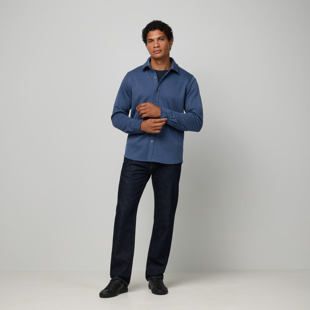 Model wearing merino wool Midweight Pique Button-Down Shirt in Vintage Blue, a medium blue color. This is a long sleeve, collared, casual button-down shirt available in sizes S-XXL.
