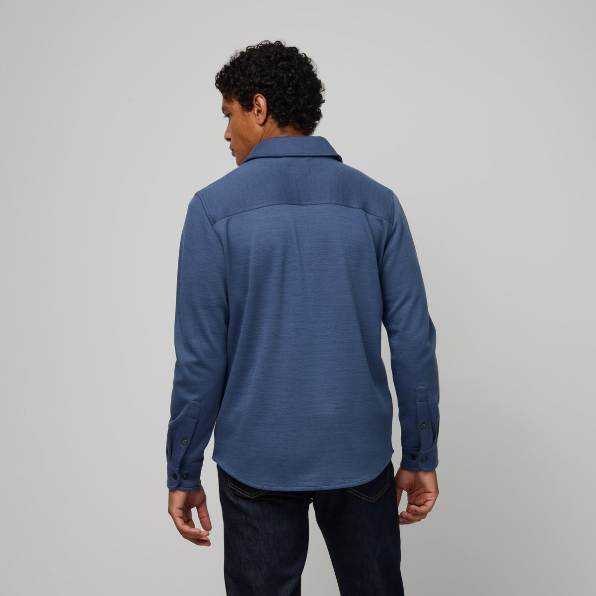 Model wearing merino wool Midweight Pique Button-Down Shirt in Vintage Blue, a medium blue color. This is a long sleeve, collared, casual button-down shirt available in sizes S-XXL.