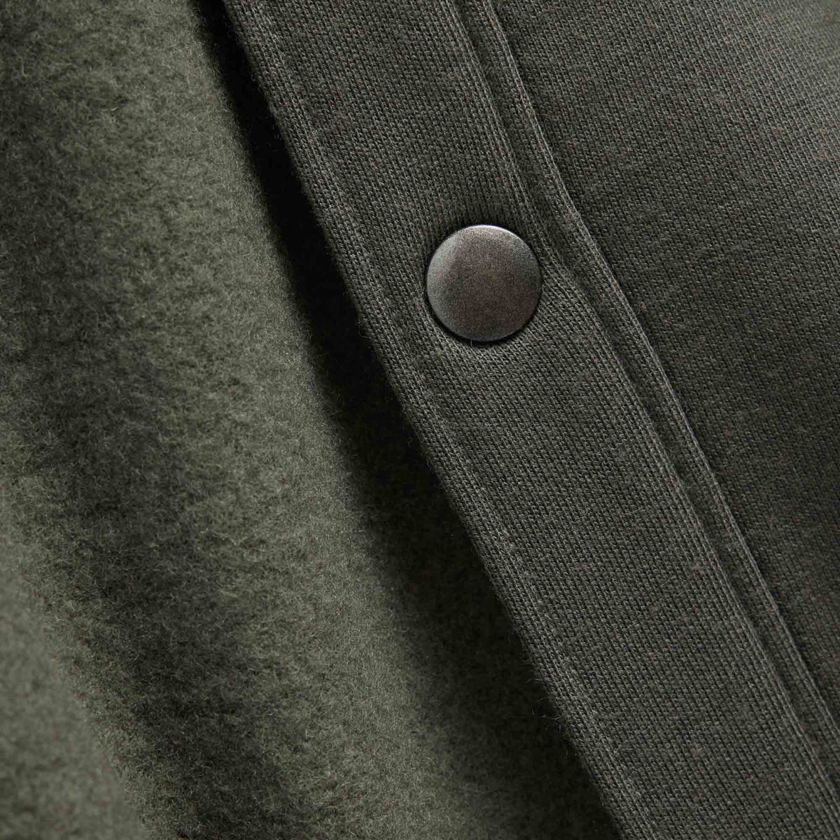 Button detail of Brushback Shacket in Forest Night, a dark forest green color. This is a 100% merino wool jacket available in sizes XS-XXL.