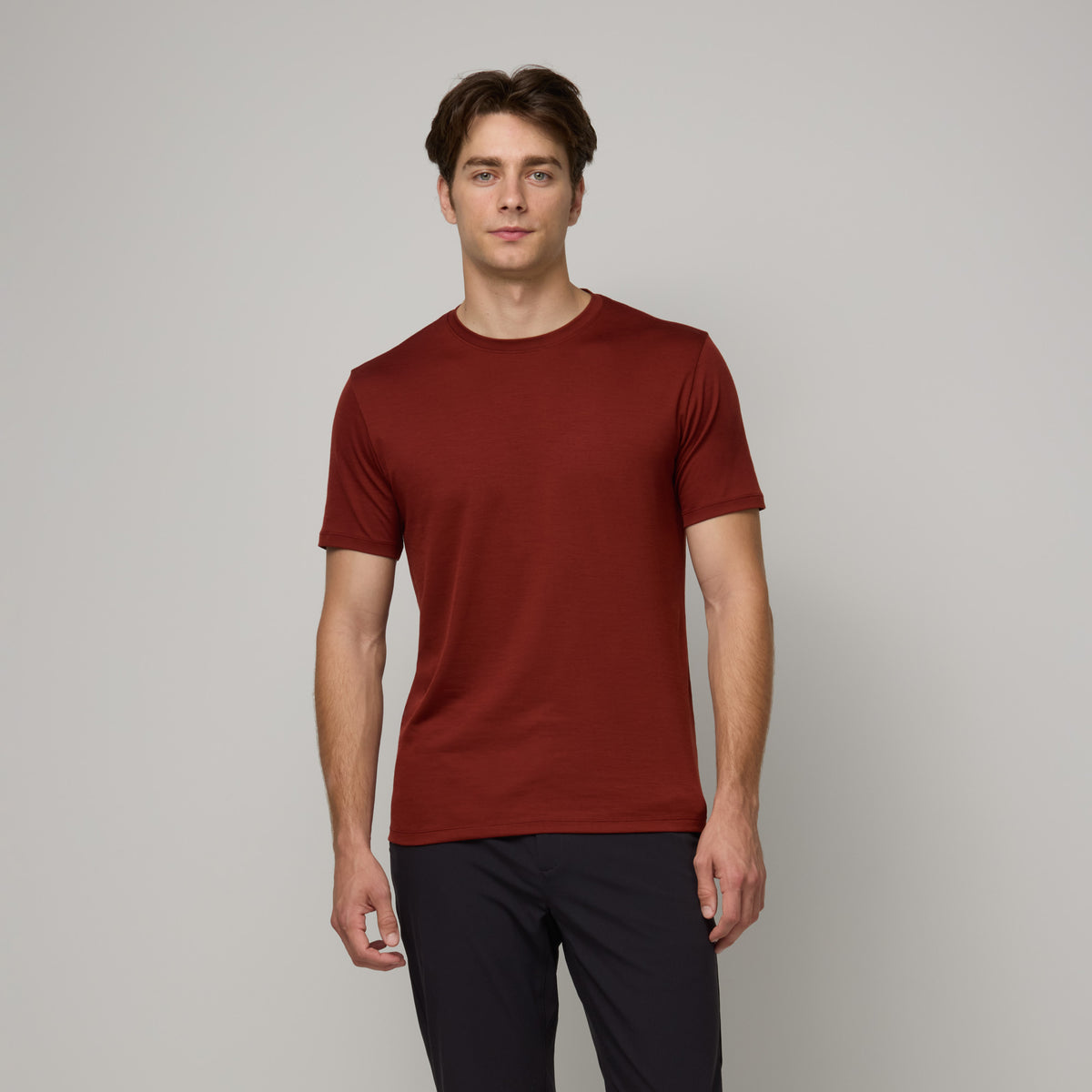 Model wearing merino wool Signature Crew Neck Tee in Rustic Red, a brick red color. This is a short sleeve, crew neck tee available in sizes XS-2X