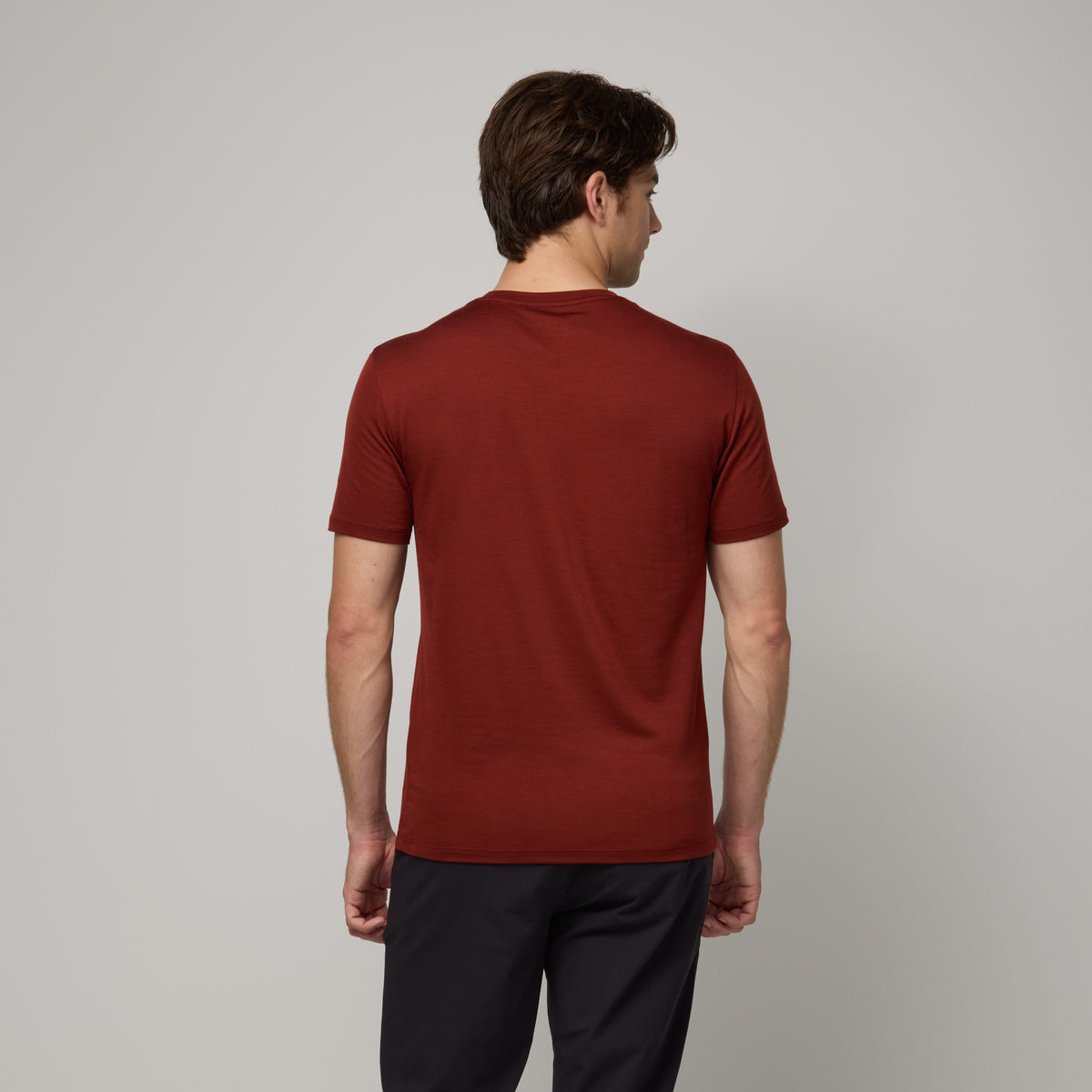 Model wearing merino wool Signature Crew Neck Tee in Rustic Red, a brick red color. This is a short sleeve, crew neck tee available in sizes XS-2X