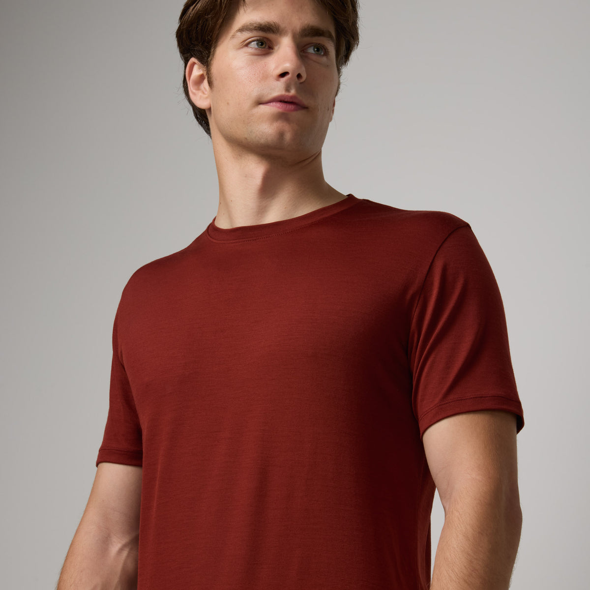 Model wearing merino wool Signature Crew Neck Tee in Rustic Red, a brick red color. This is a short sleeve, crew neck tee available in sizes XS-2X