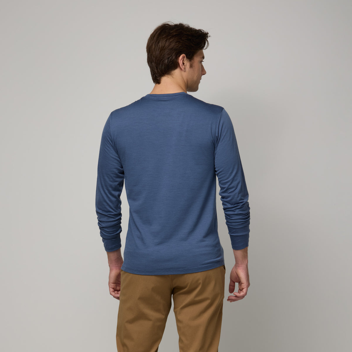 Model wearing merino wool Signature Long Sleeve Tee in Vintage Blue, a dusty blue color. This is a long sleeve, crew neck tee available in sizes XS-XXL. 