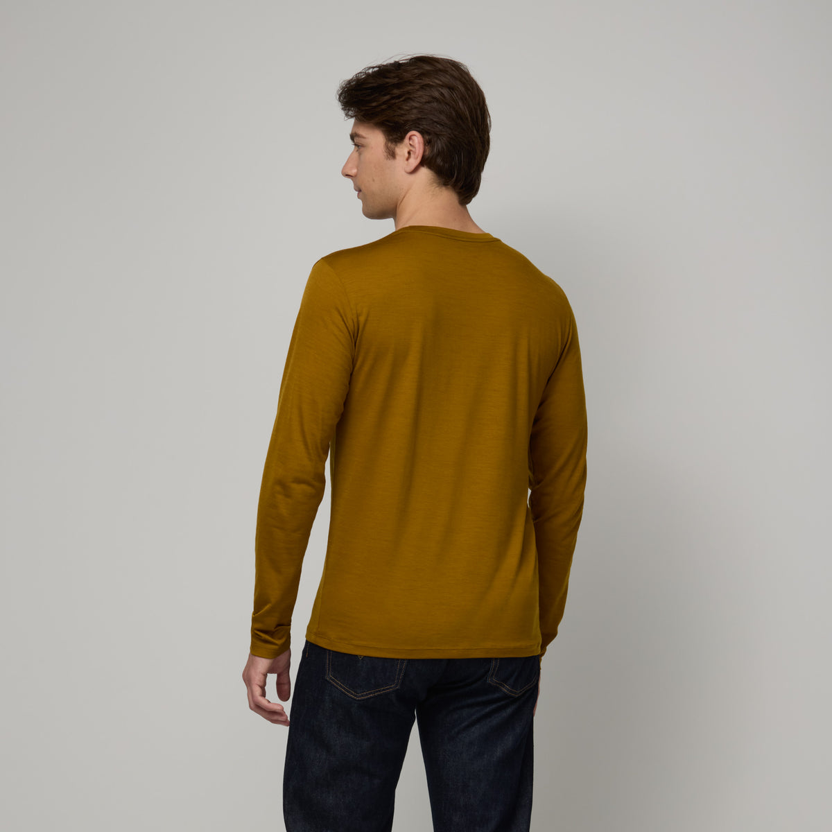 Laydown of merino wool Signature Long Sleeve Tee in Spiced Pear, a dark mustard color. This is a long sleeve, crew neck tee available in sizes XS-XXL. 