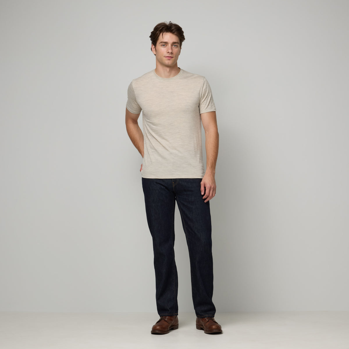 Model wearing merino wool Signature Crew Neck Tee in Oatmeal Heather, a heathered cream color. This is a short sleeve, crew neck tee available in sizes XS-2X