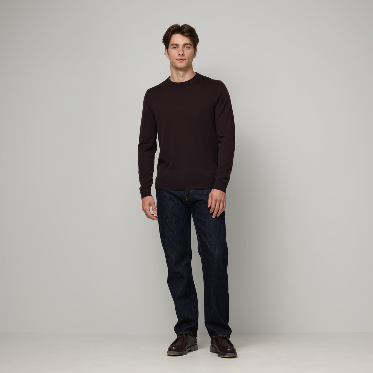 Model wearing 100% merino wool Crew Neck Sweater in Espresso, a dark brown color. This is a knit available in sizes S-XXL.