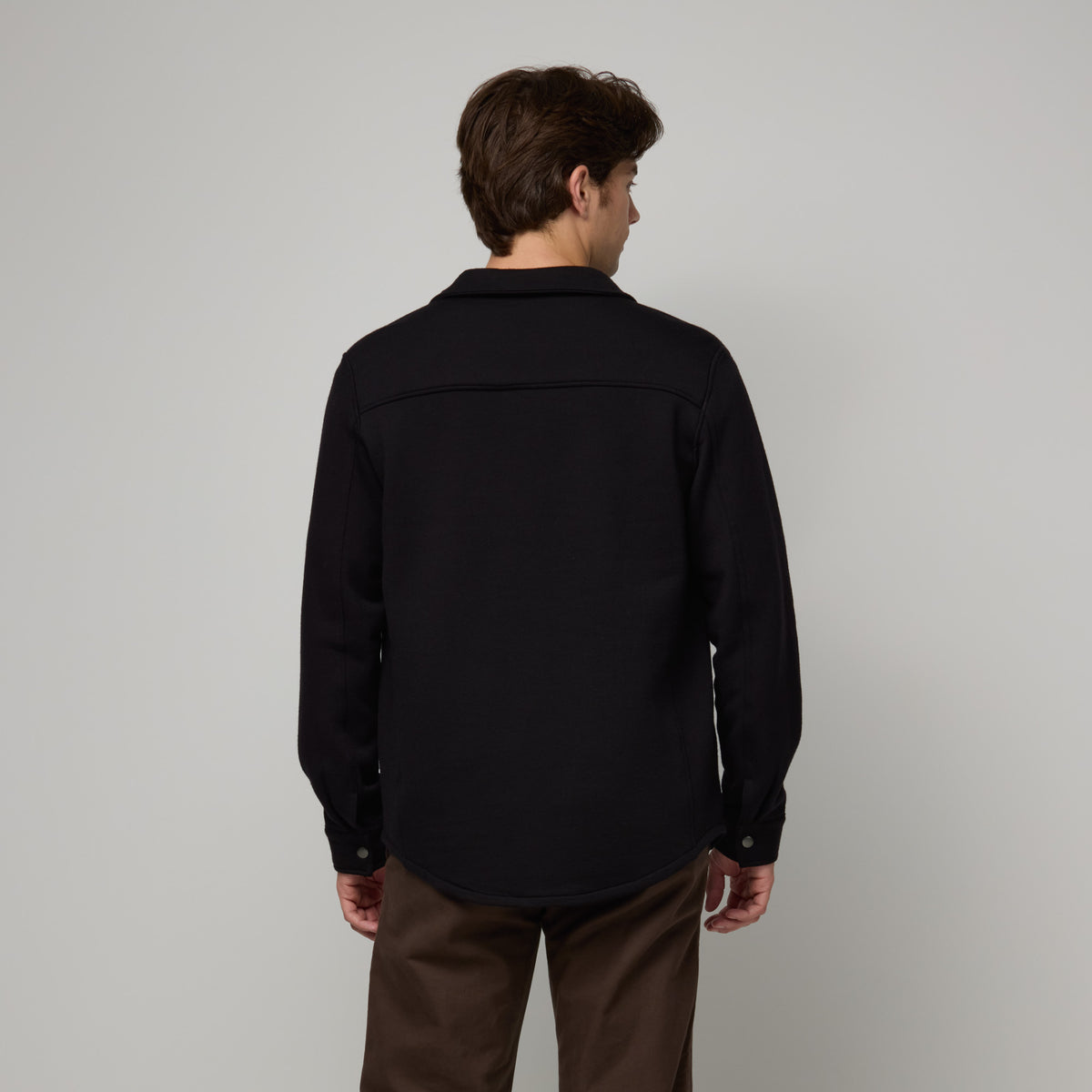 Model wearing Brushback Shacket in Black. This is a 100% merino wool jacket available in sizes XS-XXL.
