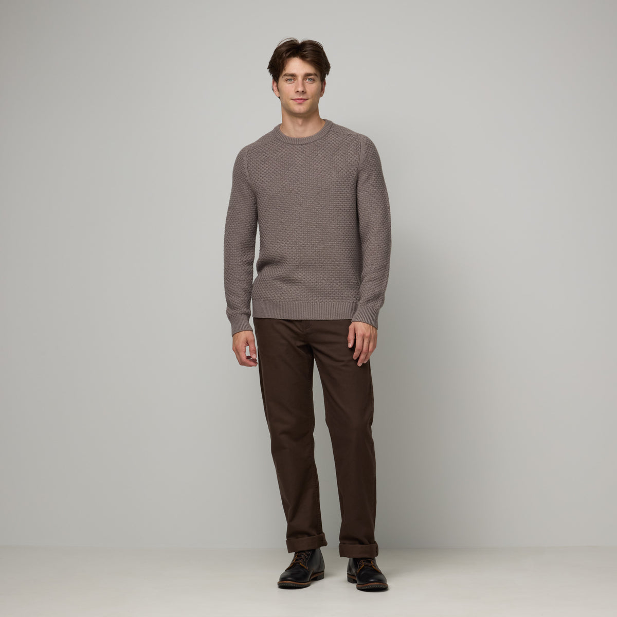 Model wearing 100% merino wool Textured Crew Neck Sweater in Brown Heather, a taupe brown color. This is a knit available in sizes S-XXL.