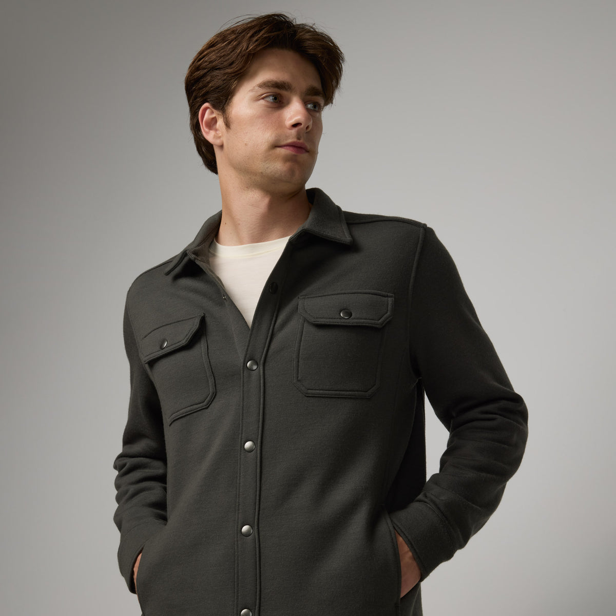 Model wearing Brushback Shacket in Forest Night, a dark forest green color. This is a 100% merino wool jacket available in sizes XS-XXL.